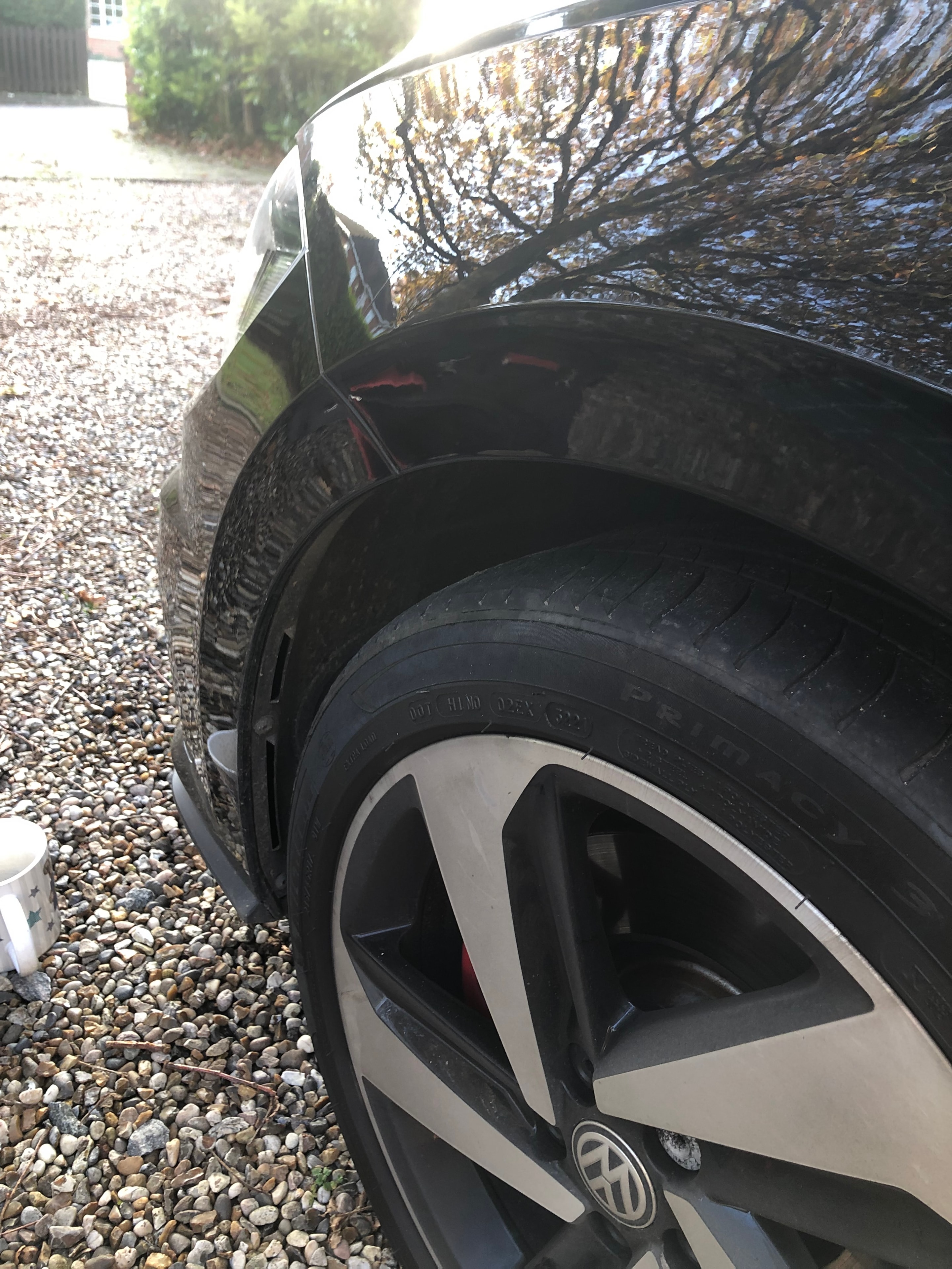 Volkswagen wheel arch dent on gravel driveway