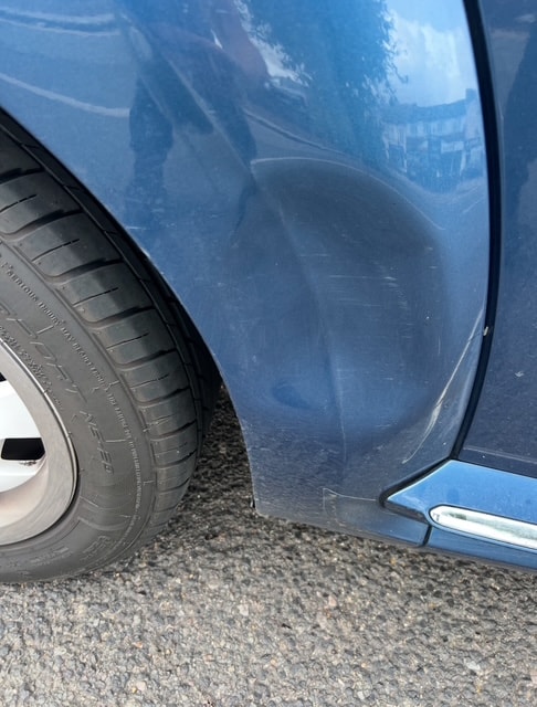 Blue car door dent damage — before PDR