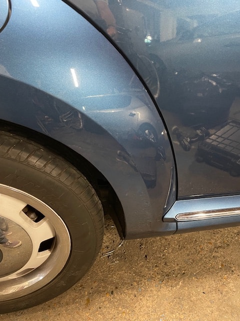 Blue car front fender dent damage